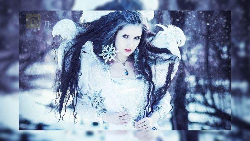 Снежная королева с длинными чёрными волосами в белом наряде.