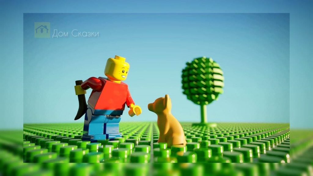 Фигурки Лего, человек и собака стоят на поле с травой