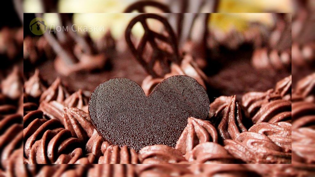 Волшебные шоколадные завитушки в центре которых лежит шоколадное сердечко покрытое капельками влаги.